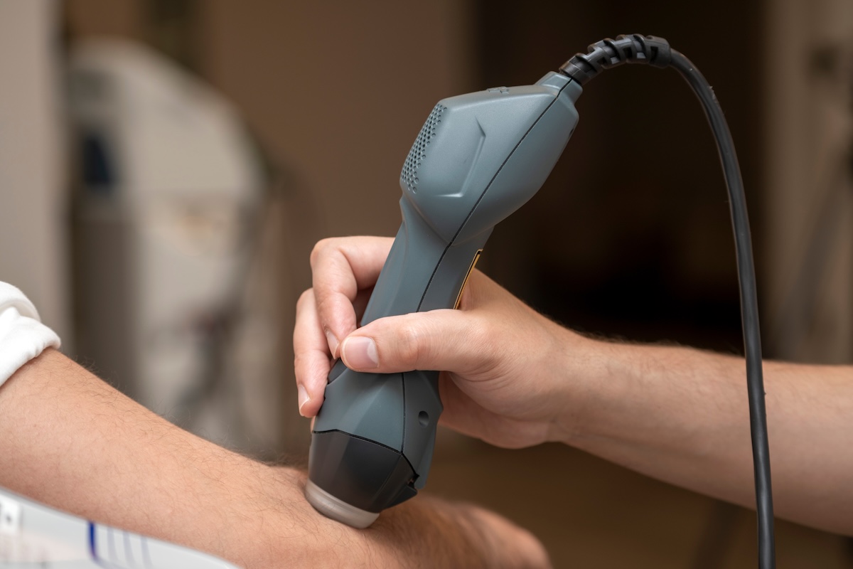 MLS laser used in sprains, muscle tears, tendonitis, brachial neuralgia, craniofacial pain, myalgia, bursitis, lumbago, arthritis, joint pain, antiedema, hematoma, edema treatments A professional chiropractor providing a lower back adjustment for a patient in a Vancouver clinic, improving mobility and reducing pain