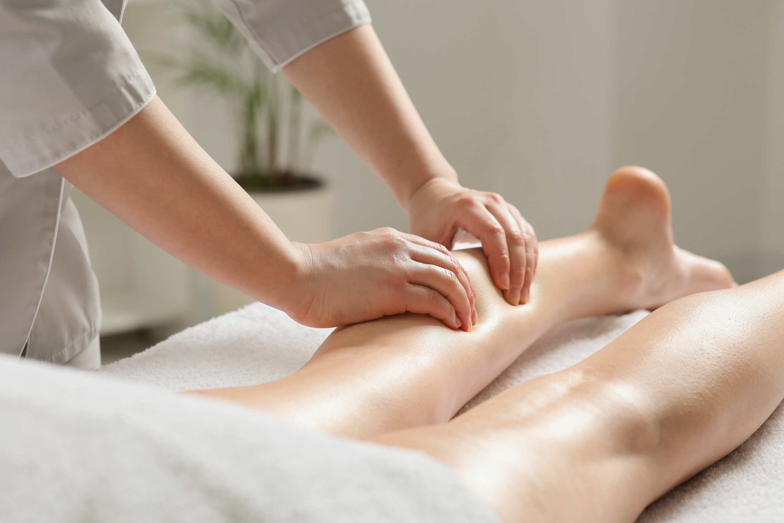 RMT performing therapeutic leg massage on client at a wellness clinic in Vancouver